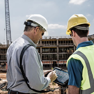 Two workers are checking the construction plans